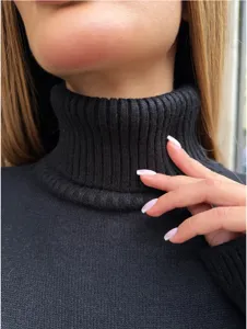 Dettaglio di abito maglione a collo alto nero in maglia con comodo colletto a coste per donna.