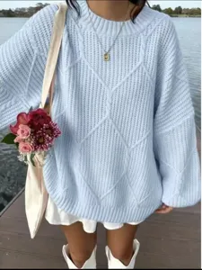 Detailaufnahme eines hellblauen Zopfmuster-Pullover mit Rautenstruktur und weichem Material.