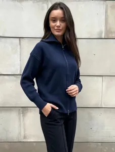 Navy blue ribbed knit zip cardigan detail showing texture, high collar and metal zipper.