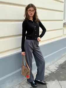 Detailansicht der schwarzen Strickjacke mit Knöpfen und feinem Rundhalsausschnitt.