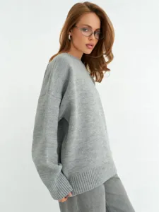 Primo piano del maglione in maglia grigio da donna, vestibilità morbida e colletto.