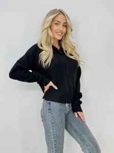 Gros plan detaille du gilet en maille noir zippe pour femme, style decontracte chic.