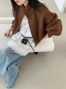 Detailaufnahme einer kuscheligen braunen Strickjacke mit Reißverschluss und Spitzentop.