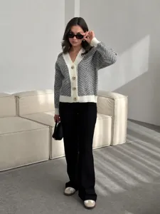 Gedetailleerd shot van een zwart-witte gebreide cardigan met V-hals en knopen in studio.