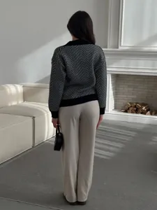Gedetailleerd achteraanzicht van de zwart-witte chevron gebreide cardigan trui in een gezellige sfeer.