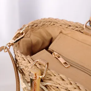 Détail de sac en paille avec texture en corde de papier, quincaillerie métallique et zip.