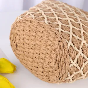 Vue détaillée en gros plan du sac en paille de papier tissé au motif ajouré élégant.