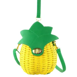 Cute pineapple shaped woven straw crossbody bag with green leather trim and stylish contrast design.