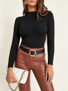 Close-up view of the black ribbed mock-neck knit sweater styled in a chic outfit.