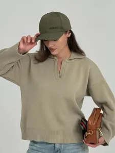Vista detallada de un elegante suéter de punto para mujer con cuello polo y bolso.