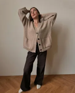 Detailed view of women's cozy knit cardigan, soft texture, V-neck and button closure design.