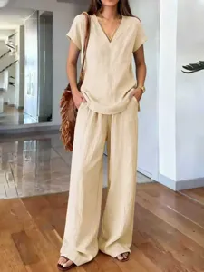 Detail shot of the solid color casual summer V-neck top and wide-leg trousers set worn.