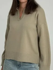 Vista detallada del suéter de punto beige casual con cuello polo elegante y manga larga.