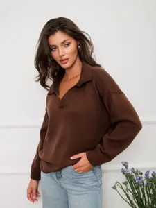 Vista detallada de un jersey de punto marrón para mujer con cuello polo y mangas largas.
