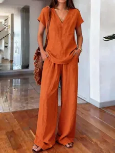Detail view of a solid color summer casual two-piece set featuring V-neck top and wide pants.