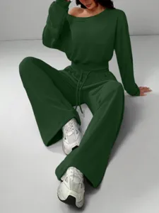 Detailed view of the dark green off-the-shoulder sweatshirt and wide-leg sweatpants set.