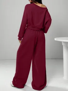 Casual burgundy off-shoulder sweatshirt and wide-leg pants tracksuit detail view, soft knit fabric.