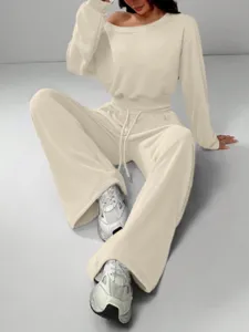 Casual beige off-the-shoulder sweatshirt and wide-leg pants detail shot, soft knit fabric.