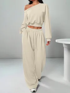 Detail shot of the stylish beige off-shoulder crop top and loose wide-leg pants set.