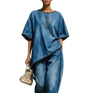 Stylish blue denim two-piece outfit with asymmetric top and loose wide-leg pants for women.