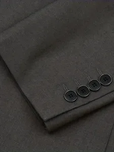 Detailed shot of a men's suit sleeve cuff with four black buttons in dark grey fabric.