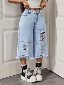 Vista dettagliata di pantaloni corti in denim chiaro slavato da donna con strappi.
