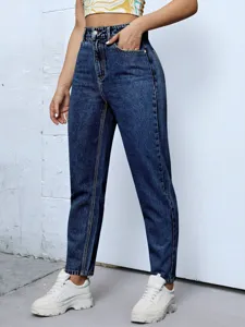Detailed view of women high waisted tapered denim jeans featuring front pockets and fit.