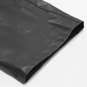 Close up detail of black PU leather pants cuff, showing fine stitching and texture.