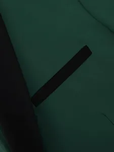Men's dark green suit jacket fabric detail, featuring black shawl lapel and welt pocket.