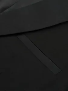 Detailed close-up of a black men suit jacket lapel texture and fabric design features.