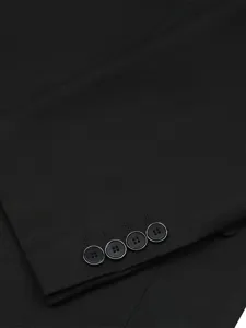 Close-up detail shot of black men suit jacket sleeve cuff with four decorative buttons.