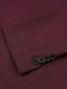 Close-up detail of burgundy men suit sleeve cuff with four black buttons. Premium formal fabric.