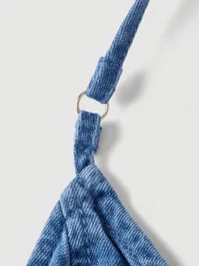 Close-up detail of blue denim dress strap with metal ring connector, stylish casual wear.