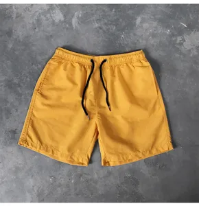 Detailaufnahme von gelben Herren Freizeithosen mit schwarzem Kordelzug für den Sommer.