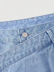 Light blue denim jeans detail shot, featuring a stylish asymmetrical crossover waistband.