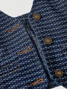 Women denim vest detail shot, blue textured fabric with bronze metal buttons, casual fashion style.