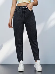 Close-up view of high-waisted black washed denim tapered jeans showing fine fabric texture.
