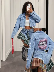 Gedetailleerd overzicht van denim jasje met gaten en geruite patchwork rok met liprint achterop.