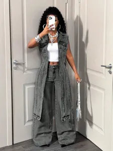 Casual sleeveless long denim vest paired with white crop top and wide-leg jeans outfit detail.