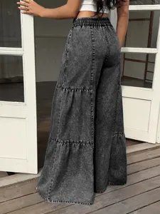 Detail view of dark grey acid wash tiered wide leg denim pants with elastic waist.