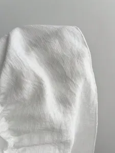 Weisser Stoff Textur Detailansicht Aufnahme des sommerlichen Damen Trägerkleides.