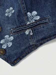 Detailed close-up of dark denim apparel featuring floral embroidery and contrast orange stitching.