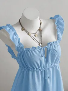 Detailansicht hellblaues Rüschen-Sommerkleid ärmellos mit Schleife und Münzkette.