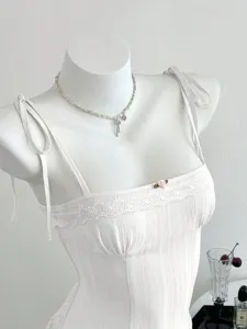Canotta bianca in pizzo con vestibilità slim, spalline delicate e grazioso fiocco per lo stile estivo.