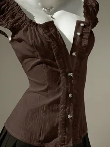Detail view of women's brown short sleeve blouse featuring ruffles and bubble sleeves.
