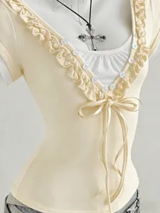 Dettaglio della maglietta beige slim a maniche corta con scollo a V con volant e fiocco.