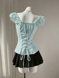 Light blue off-shoulder puff sleeve blouse paired with a chic black pleated miniskirt.