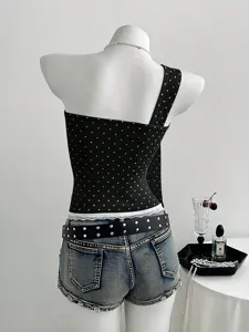 Detailed view of European style black polka dot one shoulder top with denim shorts.