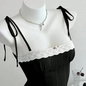 Top canotta nero da donna con inserto in pizzo bianco e spalline con fiocco.