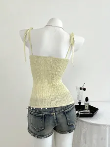Vista dettagliata del top smock giallo, caratterizzato da un design con spalline eleganti e fini.